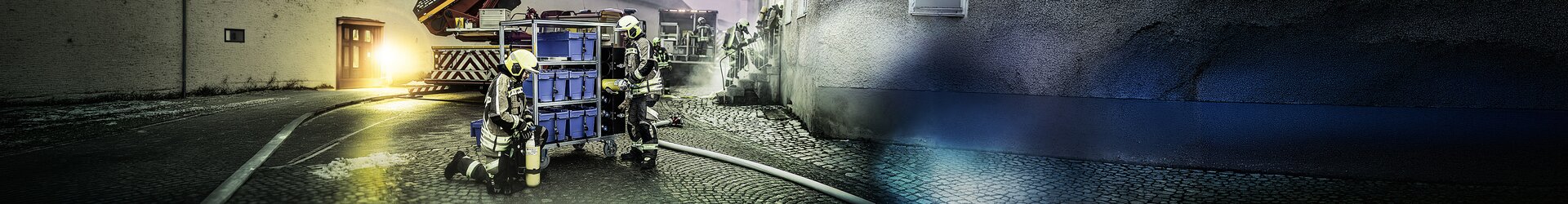 Firefighters operate a mobile container in a tight alley, fire engine in the background | © MUNK GmbH